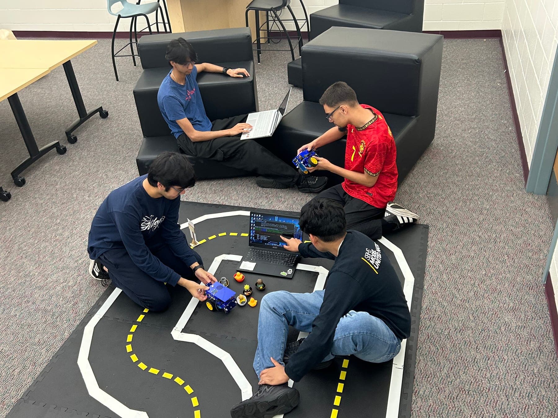 Academy students testing a DuckieBot on the Duckietown track
